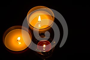 Three candles over black backdrop