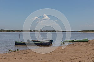 Three canoes moored on the river bank
