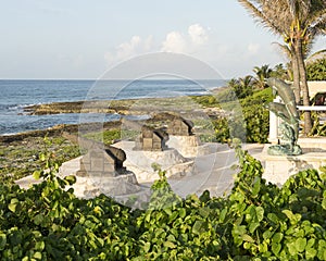 Three canon sculptures and bronze dolphin statue on the shore of Fatima Bay