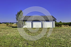 Three car garage with tile roof. Countryside landscape photo