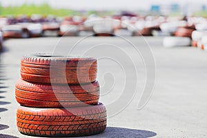 Three car tires stacked on top of each other on an empty track race track, no one