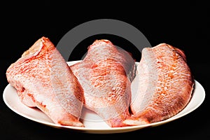 Three carcasses of sea bass in a white plate