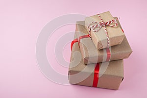 Three cardboard gift boxes from recycled paper on a pink background. Copy space