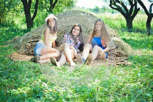 Three carefree teenagers lying on heap of hey