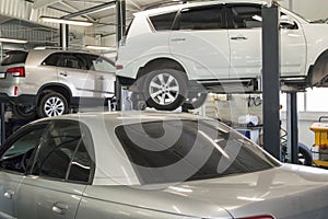 Three cars in a car repair shop