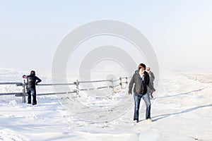 Three caucasian ladies walking in a snowy field.