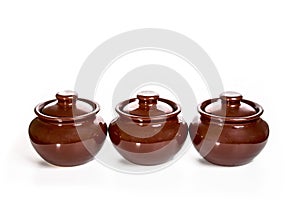 Three ceramic pots for oven isolated on white background