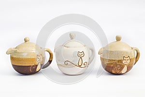 three ceramic teapots stoneware with white background