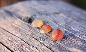 Three chalcedony agate gemstones on wooden background