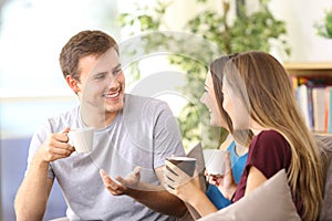 Three cheerful friends talking at home