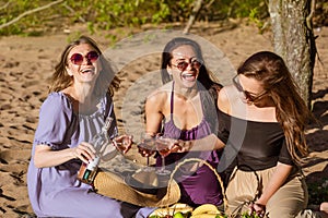 Three cheerful girlfriends at a summer picnic. Happy women