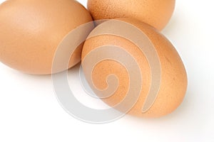 Three chicken eggs on a white background.