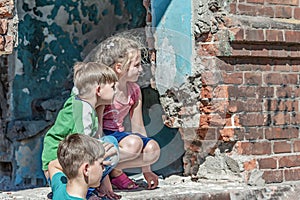 Three children in a destroyed house are hiding from military con