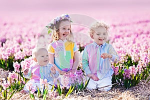 Three children playing in beautiful hyacinth flower field.