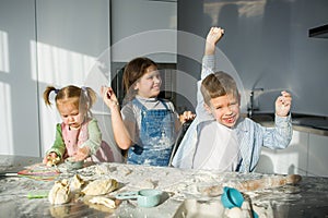 Three children prepare something from the dough.