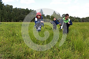 Three children running across field