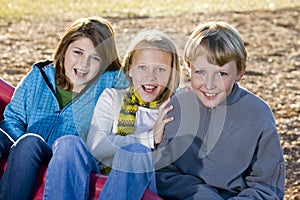 Three children sitting on slide