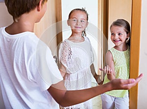 Three children standing at house entrance