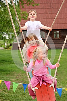 Three children on swing