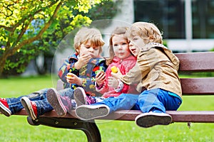 Three children: two little boys and one girl hugging.