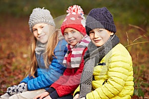 Three Children On Walk Through Winter Woodland