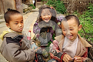 Three Chinese children having fun near the farmhouse, Basha Miao Village, Congjiang County, Southeast Guizhou Province, Southwest