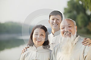 Three Chinese People With Tai Ji Clothes Smiling At Camera