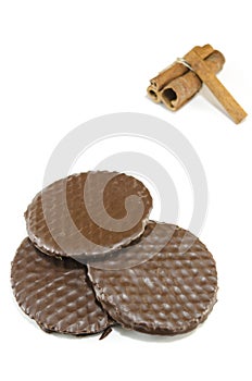 Three chocolate biscuits and cinnamon sticks isolated