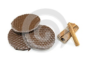 Three chocolate biscuits and cinnamon sticks isolated