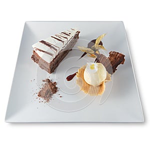 Three-chocolate cake plate with a scoop of vanilla ice cream and a physalis.