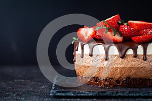 Three chocolates cake with chocolate drips on a black background. Layered cake with milk, black and white chocolate souffle