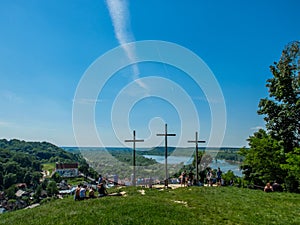 Three christian crosses on the hill with people en