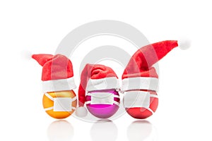 Three christmas balls isolated on white wearing a surgical face mask, corona concept