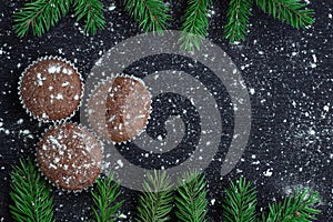 Three Christmas cakes, winter snowbound black background, fir tr
