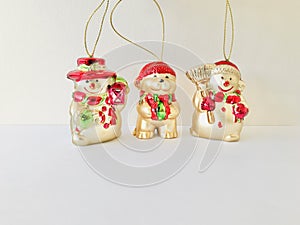Three Christmas charms, a bear and two snowmen. golden ornaments.