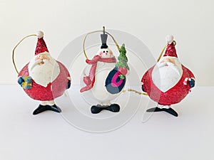 Three Christmas charms, a snowman and two Santa Claus. Retro ornaments.