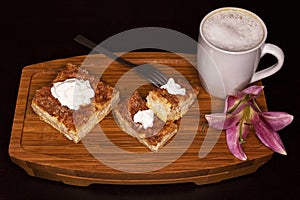 Three Churro Cheesecake pieces, one fork, one flower and a drink on a wooden base