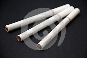 Three cigarettes on the black background