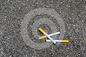 Three cigarettes lying on the pavement