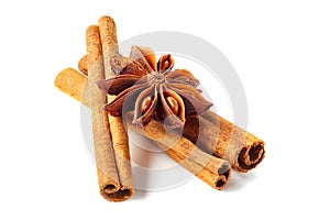 Three cinnamon sticks and star anise on white