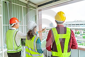 Civil engineers team with one female is discussing about transporation construction site