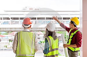 Three Civil engineers with one female is discussing about transporation construction site