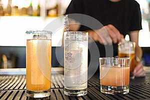 Three classic cocktail glasses with barman