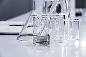 Three clear beakers on white marble tabletop.
