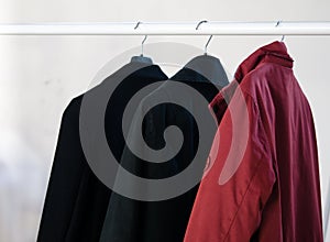 Three coats hanging on a coat rack