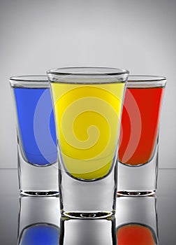 Three cocktails yellow red and blue colors in three wine-gla