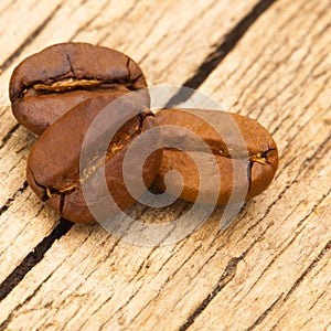 Three coffee beans on old table - close up shot