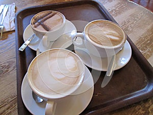 Three Coffee beverages on a tray