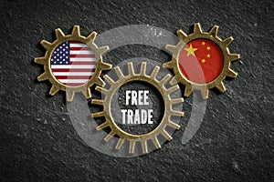 Three cogwheels on slate background with the flags of USA and the China and the words `free trade `