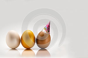 three color eggs with bithday hat